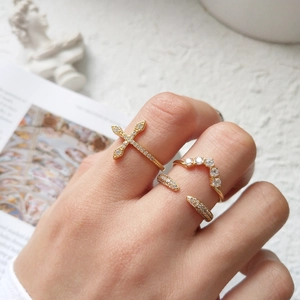 Three gold zircon rings featuring cross and curved designs on a model for French elegance