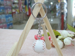 Close-up of a mini baseball keychain with a wooden bat and a white stitched leather ball