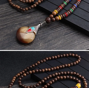 Detail shot of vintage ethnic wood bead necklace with decorative stone pendant