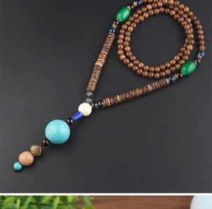 Detailed close-up of ethnic necklace featuring turquoise, wood beads and stone pendants