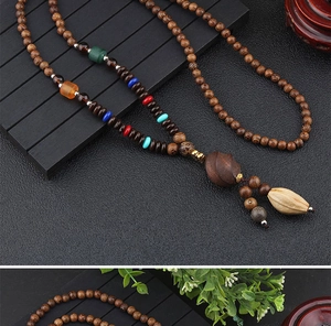 Macro detail of ethnic wooden bead necklace with colorful accents and tassel pendant