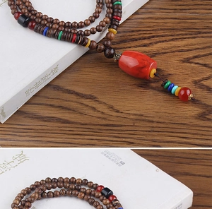 Detail view of ethnic style long necklace with dark wood beads and colorful spacer accents