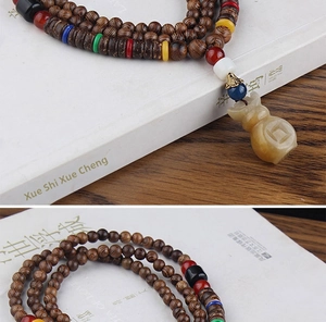 Close-up of wooden bead necklace with a carved money bag pendant and colored spacer beads