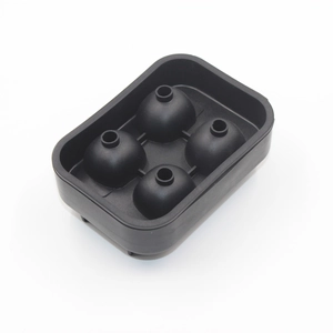 Detail of black silicone mold for four spherical ice cubes with fill holes on white background