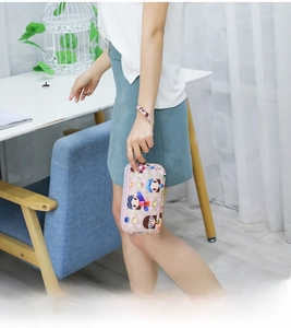 Roze mini canvas tasje met cartoon print in de hand gehouden, compact en schattig voor vrouwen