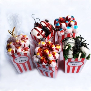 Detail of Halloween props showing skull and eyeball in popcorn boxes on white background