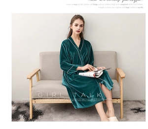 Close-up of velvet bathrobe texture with white piping detail on dark green fabric