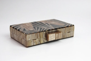 Macro view of shell texture acrylic clutch bag showing magnetic opening and closing detail