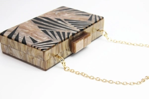 Top view of marble texture acrylic clutch with geometric patterns and gold chain