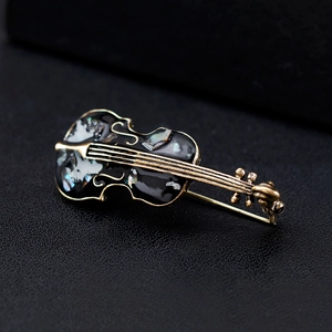 Retro cello brooch with shell inlay and gold plating on black leather background