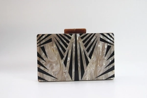 Detail view of rectangular acrylic clutch featuring black and white geometric marble pattern
