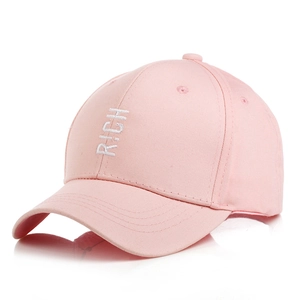 Detail of pink cotton baseball cap with white RICH embroidery and curved brim