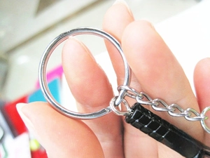 Close-up of a silver keychain with a black textured handle pendant and durable chain