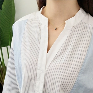 Close-up of 925 sterling silver gold necklace with a black rectangular pendant on model