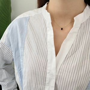 Detail of 925 sterling silver necklace with black rectangular pendant on model neck