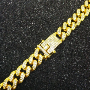 Detailed close-up of 18K gold-plated Cuban chain link with iced-out pave diamonds and clasp