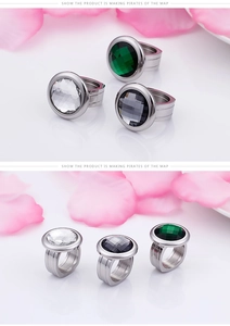 Detailed view of chunky stainless steel rings featuring large round emerald and clear stones