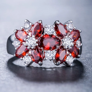 Dettaglio macro dell'anello cluster con pietre marquise rosse e zirconi bianchi