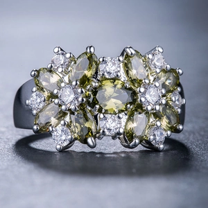 Dettaglio macro dell'anello con gemme verde oliva taglio marquise e zirconi bianchi