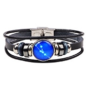 Detail view of Taurus zodiac sign on blue glass gem with black woven leather bracelet