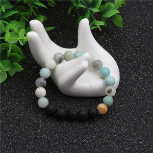 Vue détaillée d'un bracelet de 8mm en perles de lave et aigue-marine sur main modèle