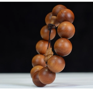 Macro detail of natural sandalwood prayer beads showing brown grain and polished finish