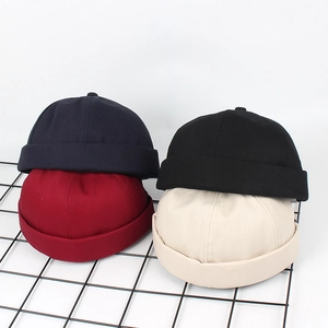 Stylische Docker-Mützen in Marine, Schwarz, Weinrot und Beige auf minimalistischem Gitter