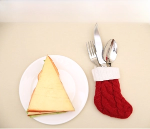 Gros plan sur un porte-couverts en forme de chaussette de Noël tricotée rouge et blanche