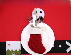 Détail de chaussette de Noël en tricot rouge et blanc avec des couverts en argent sur table