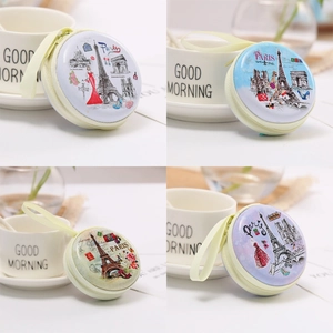 Detail of four colorful round tinplate coin purses featuring Paris-themed illustrations