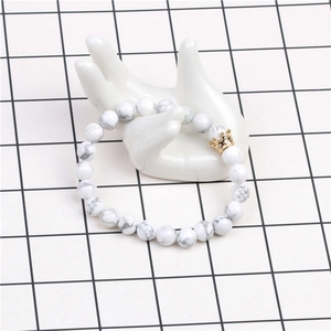 Gros plan détaillé de perles howlite 8mm et couronne dorée sur un bracelet pour hommes