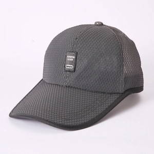 Detailed macro view of breathable mesh fabric and logo patch on dark gray sun cap
