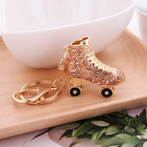 Detail of a pink rhinestone roller skate keychain with gold alloy finish and D-ring clip