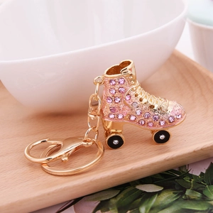 Close-up of pink rhinestone roller skate keychain with golden metal ring and lobster clasp