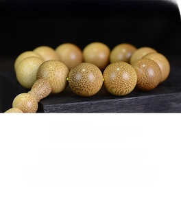 Macro detail of natural golden silk bamboo beads showing unique wood grain texture