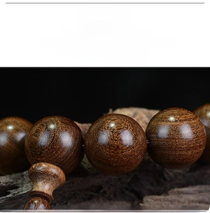 Macro shot of polished dark sandalwood prayer beads with natural wood grain detail