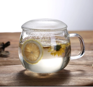 Detail of heat-resistant glass tea mug with lid featuring floating lemon and chrysanthemum