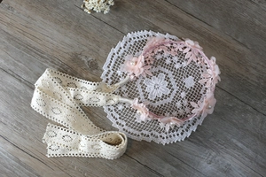 Detalle de las flores de tela rosa y la cinta de encaje beige en la diadema de bebé