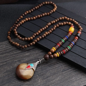 Ethnic wood bead necklace with colorful accents and a large patterned agate pendant