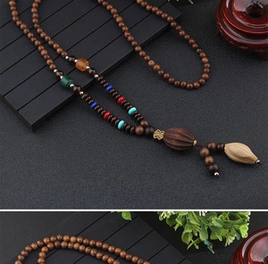 Detailed close-up of ethnic wood bead necklace with lotus pod pendant and color accents