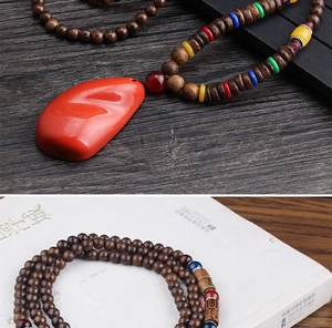 Detailed view of ethnic wood bead necklace with a vibrant red teardrop-shaped pendant