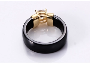 Detail of 6mm black ceramic ring with gold four-prong setting and round cubic zirconia