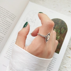 Detailed macro of vintage silver ring featuring an oval stone and textured band