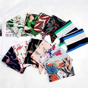 Flat lay di vari foulard in seta con motivi floreali e fenicotteri per capelli o collo