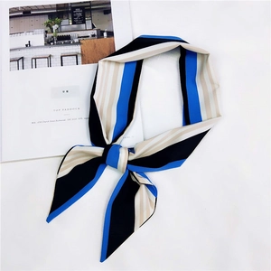 Dettaglio del lussuoso foulard in seta a righe drappeggiato su una rivista