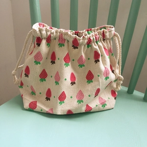 Vue détaillée du sac bento en toile crème avec un imprimé à motif de fraises mignonnes