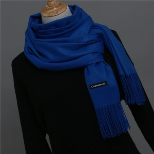 Detailed view of royal blue cashmere scarf featuring soft fringe and stitched fabric label