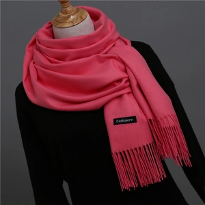 Detail of pink cashmere scarf featuring soft twill weave texture and long fringe tassels