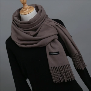 Detail of coffee brown cashmere scarf showing fine knit texture and fringe tassels