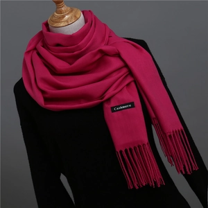 Detailed close-up of dark rose cashmere scarf with fine tassels and texture